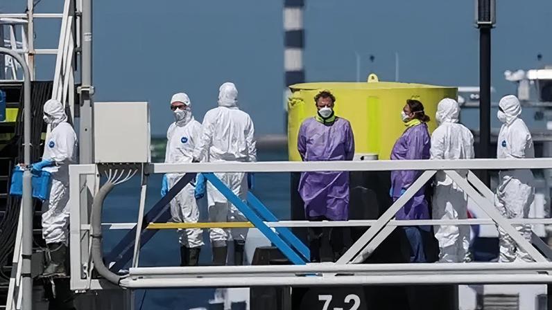 Workers in protective gear were seen on board the MV Hondius after its arrival in Rotterdam