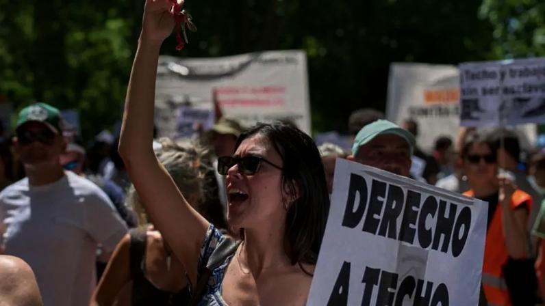 Manifestante segura placa com os dizeres em espanhol: "Direito à moradia" durante uma manifestação realizada em Madri, Espanha, em 24 de maio.