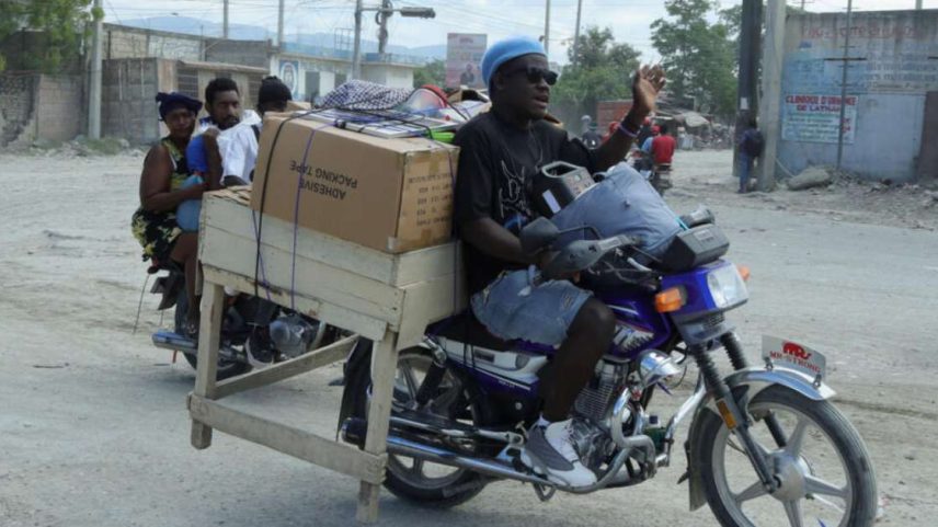 Moradores transportam seus pertences em motocicletas enquanto fogem de suas casas em Cité Soleil, após o agravamento dos confrontos entre gangues rivais na capital haitiana durante o fim de semana, em Porto Príncipe, no Haiti, em 11 de maio de 2026.
