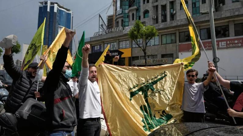 Apoiadores do Hezbollah agitam a bandeira da milícia pró-iraniana em 17 de abril de 2026 em Dahiyeh, um subúrbio de Beirute.
