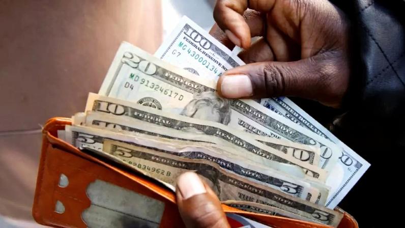 Pessoa exibe notas de dólar americano após sacar dinheiro em um banco em Harare, Zimbábue, 9 de julho de 2019. REUTERS/Philimon Bulawayo