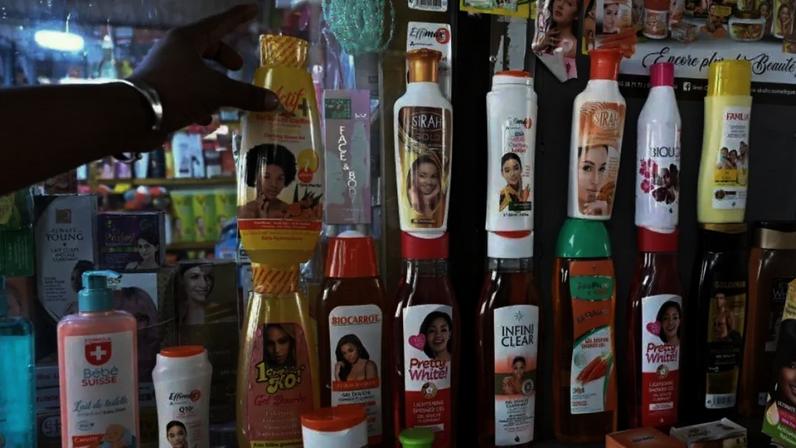 Diversos frascos de produtos de clareamento da pele, de diferentes fabricantes, expostos sobre uma mesa