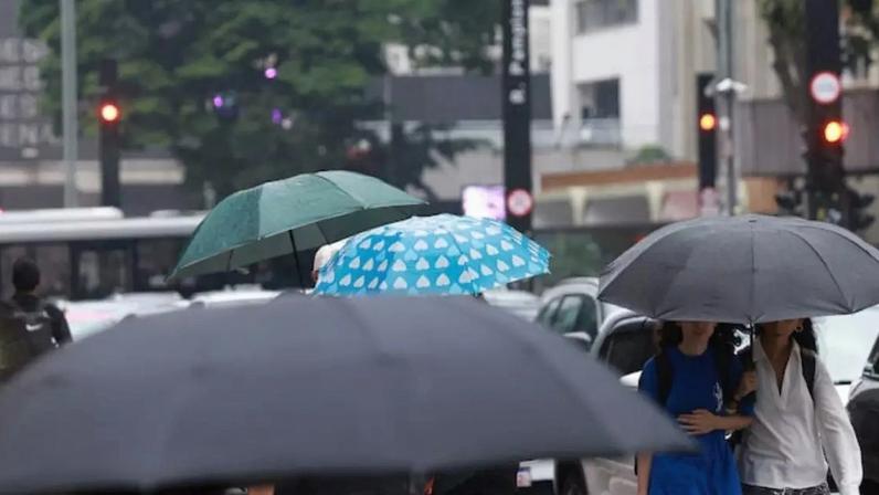 Pedestres caminham com guarda-chuva na Av. Paulista