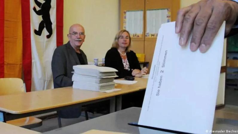 Mesários observam eleitor depositando cédula eleitoral em Berlim. Ao menos 14 milhões de pessoas que vivem na Alemanha são estrangeiras