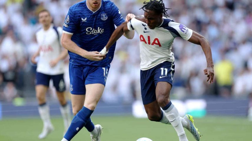 Jake O’Brien (de azul) tenta evitar que Mathys Tel leve o Tottenham ao ataque.