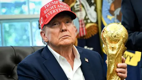 Trump holds the FIFA World Cup trophy in the Oval Office of the White House