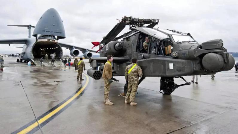 Imagem de arquivo mostra um helicóptero de ataque AH‑64 Apache posicionado diante de um avião de transporte C‑5 Galaxy na Base Aérea dos EUA em Ramstein, no oeste da Alemanha, em 22 de fevereiro de 2017.