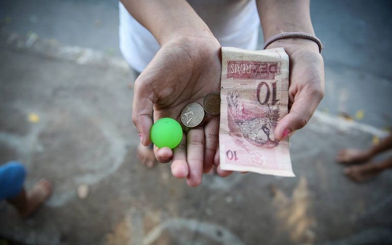 Criança segura dinheiro de trabalho em praça na capital paulista - Zanone Fraissat - 11.jul.19/Folhapress