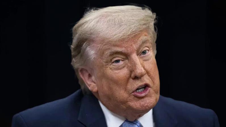O presidente dos EUA, Donald Trump, senta em uma cadeira de couro e fala