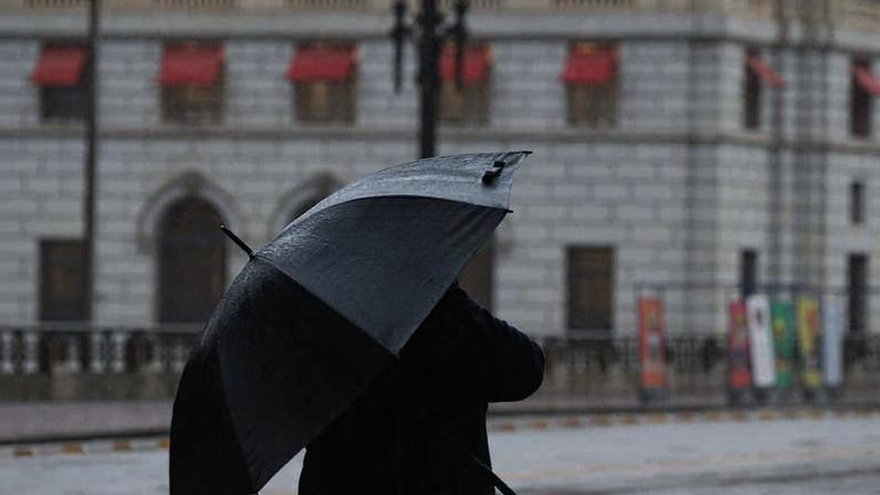 Pedestre se protege do frio e da garoa no viaduto do Chá, na região central de São Paulo; previsão para esta segunda (4) é de chuva fraca e temperatura máxima de 23°C