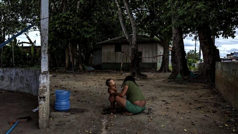 Indígena yanomami da região do rio Padauiri dá banho em criança na casa de apoio da Funai em Barcelos (AM), cidade que recebe mensalmente centenas de yanomamis em busca de beneficios sociais