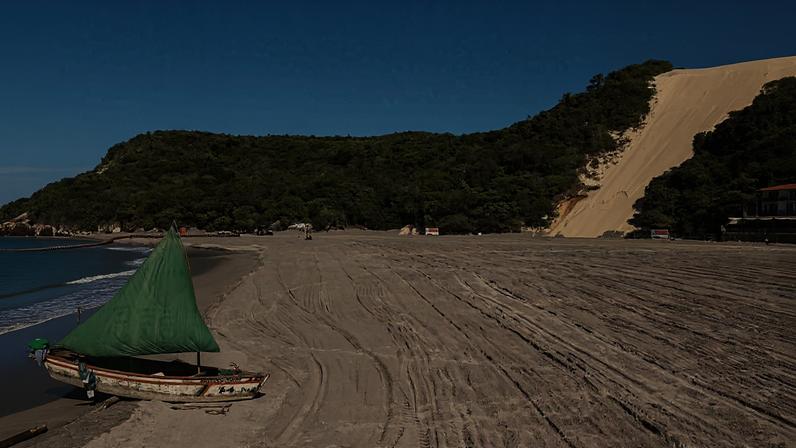 Faixa de areia na Praia de Ponta Negra após o processo de engorda; o Morro do Careca está ao fundo
