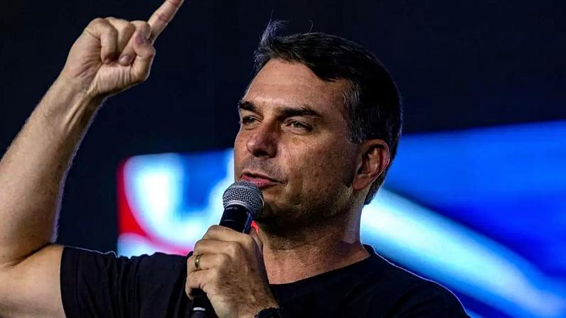 Flávio Bolsonaro falando ao microfone com o dedo levantado