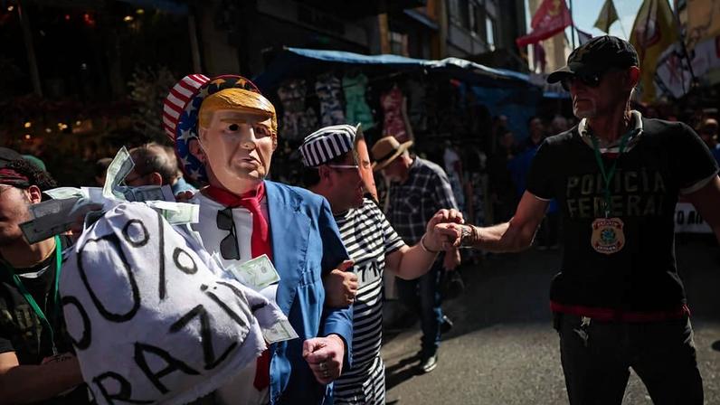 Ato do Sindicato dos Comerciários de São Paulo na região da rua 25 de Março, no centro da capital, com críticas ao Pix, tarifas e soberania nacional, em julho de 2025. Manifestantes exibiram bonecos representando Donald Trump e Jair Bolsonaro, além de faixas e encenações com trajes de presidiário e policiais