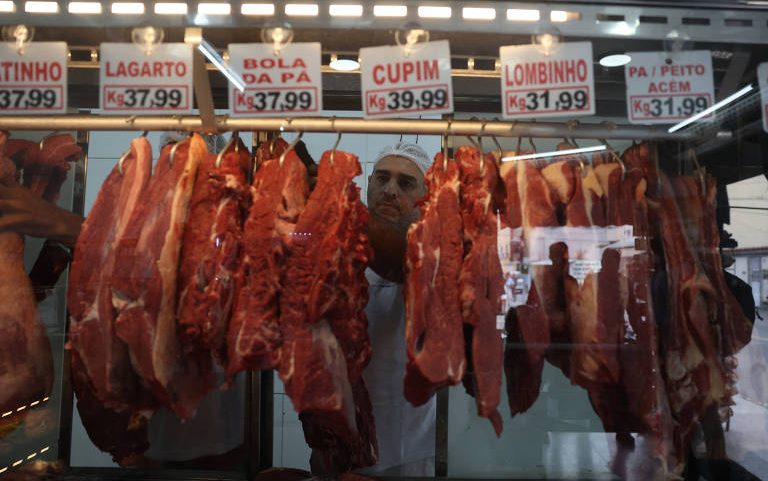 Funcionário manuseia cortes de carne em açougue do Rio de Janeiro