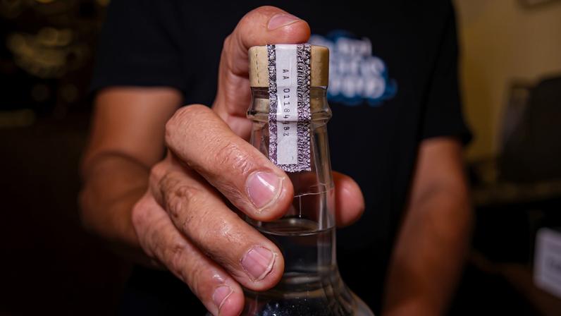 Lacre de segurança em garrafa de cachaça em bar na região da Santa Cecília, no centro de São Paulo