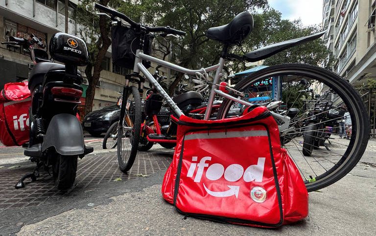 Mochila de entregas do iFood, plataforma líder em delivery no Brasil, ao lado de uma bicicleta no Rio de Janeiro