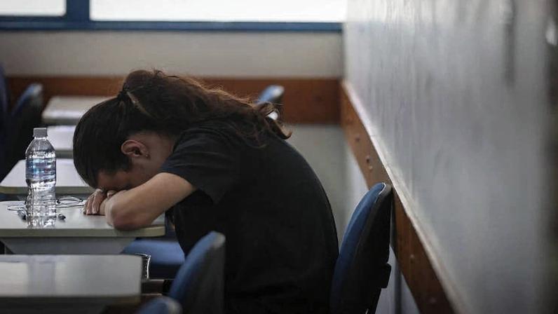 Estudante exausta espera o início de uma prova em uma sala de aula, em São Paulo