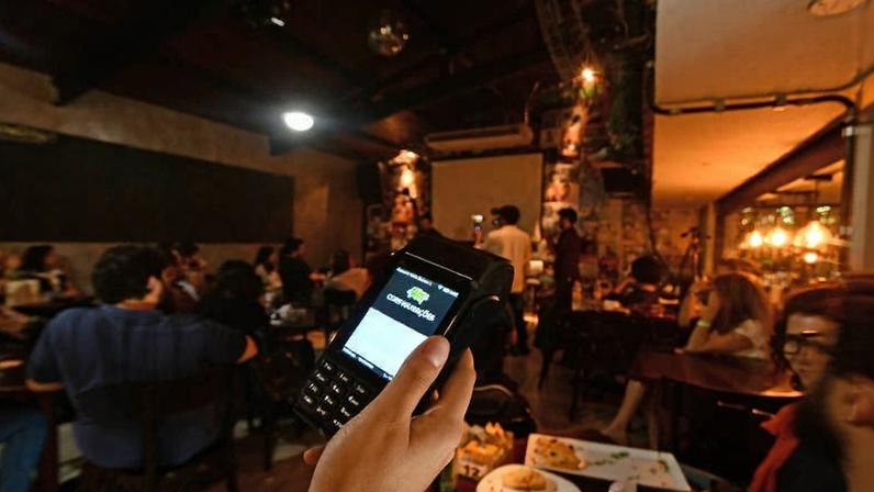 Cliente utiliza maquininha de cartão em restaurante - Karime Xavier - 18.jul.18/Folhapress