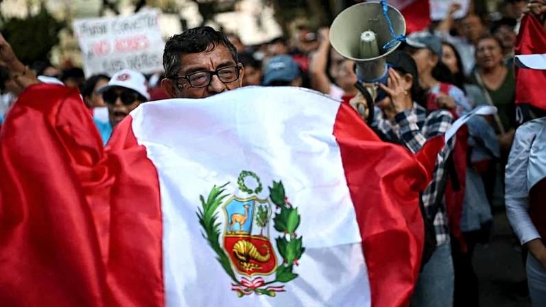 Manifestantes com a bandeira do Peru durante protesto em frente ao Conselho Nacional Eleitoral, órgão máximo das eleições no país, em Lima, em abril