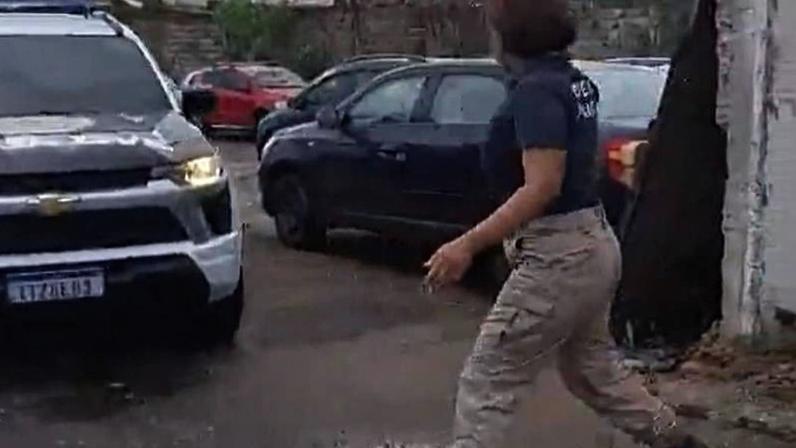 Imagem mostra uma viatura adesivada da Polícia Civil deixando um depósito da Prefeitura do Rio.