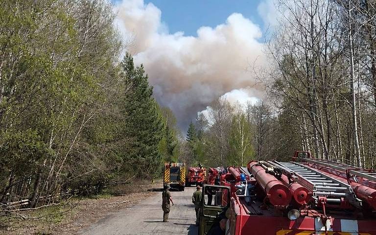 Caminhões de bombeiros diante de incêndio florestal na zona de exclusão de Tchernóbil, na Ucrânia