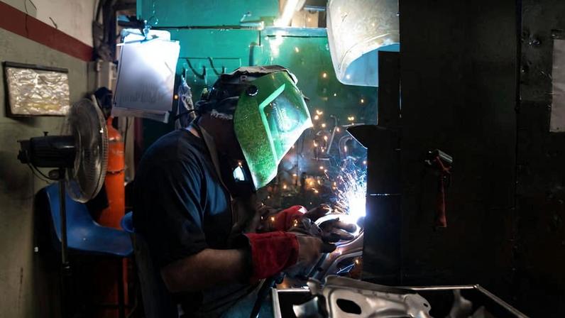 Um homem trabalha na Suspenmec, empresa de autopeças que produz braços de controle para suspensões de carros e fornece peças para oficinas de reparo de carros usados, em Sarandi, nos arredores de Buenos Aires, Argentina, em 17 de abril de 2026