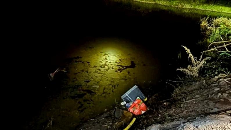 Bombeiros iluminam lagoa durante buscas de veículo onde estavam as vítimas