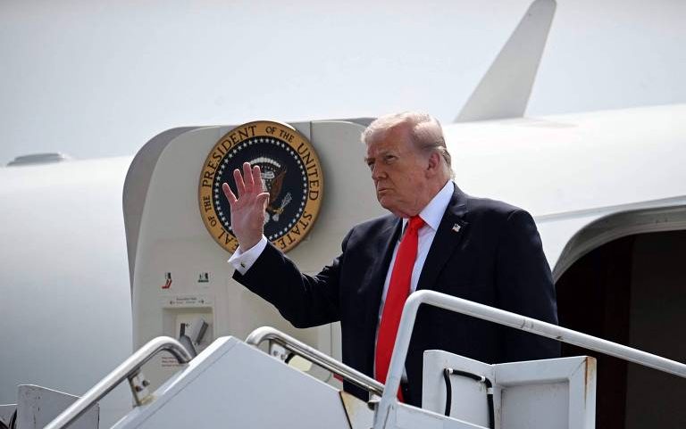 Donald Trump acena na entrada do Air Force One
