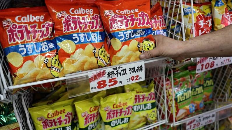 Cliente escolhe batatas fritas da Calbee em loja no Japão