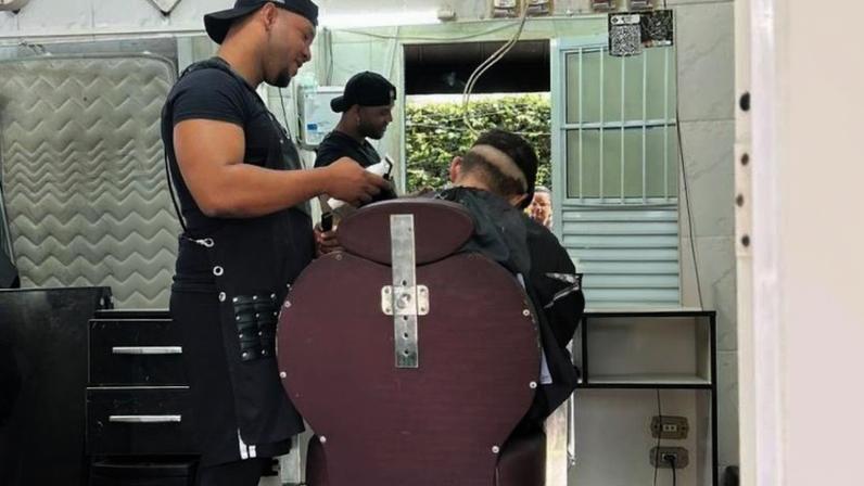 Yelier Soria Riso reabre as portas da barbearia, onde também vive; aos poucos, os primeiros clientes retornam