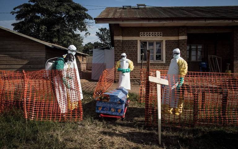 Profissionais de saúde desinfetam o caixão de um paciente falecido com suspeita de Ebola dentro de um Centro de Tratamento de Ebola administrado pela Aliança para Ação Médica Internacional, em Beni
