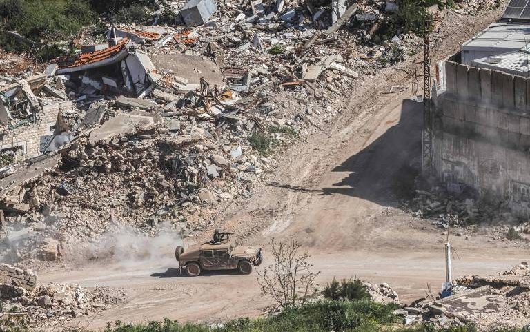 Veículo militar israelense em meio a destroços no sul do Líbano, perto da fronteira com Israel