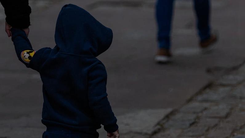 Criança caminha se protegendo do frio com agasalho no Largo da Batata, zona oeste de São Paulo