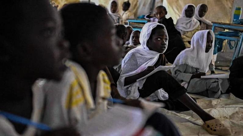 Crianças sudanesas deslocadas pelo conflito estudam em acampamento humanitário