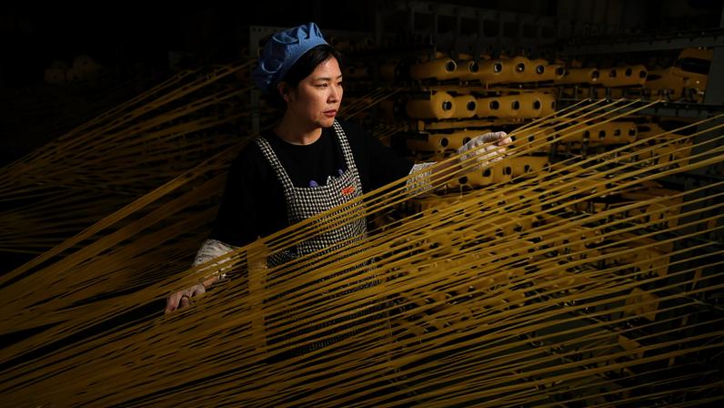 Uma trabalhadora na linha de produção de uma empresa no distrito de Lianyun, na China - Wang Chun - 18.mai.2026/Xinhua