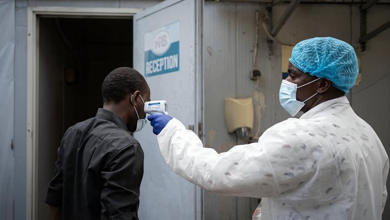 Profissional de saúde verifica temperatura de homem em Goma, na República Democrática do Congo