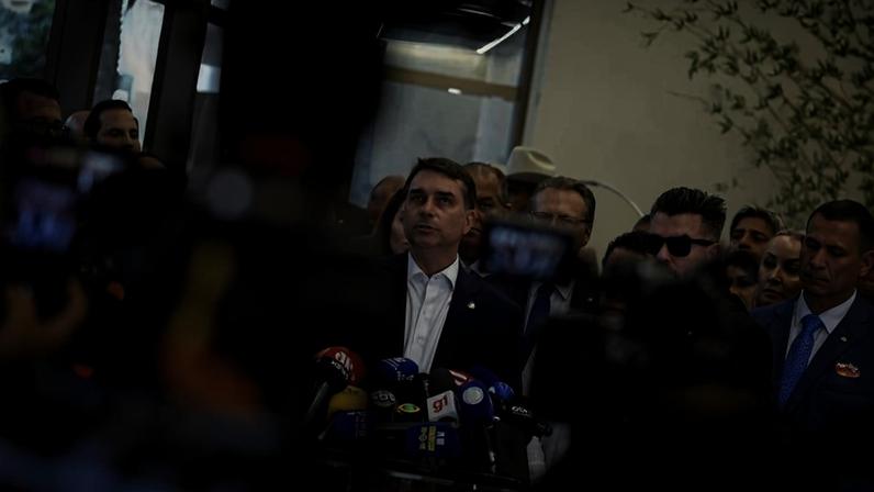 O senador Flávio Bolsonaro, acompanhado de integrantes da bancada do PL na Câmara e no Senado, faz uma declaração à imprensa após reunião do partido sobre o caso "Dark Horse"