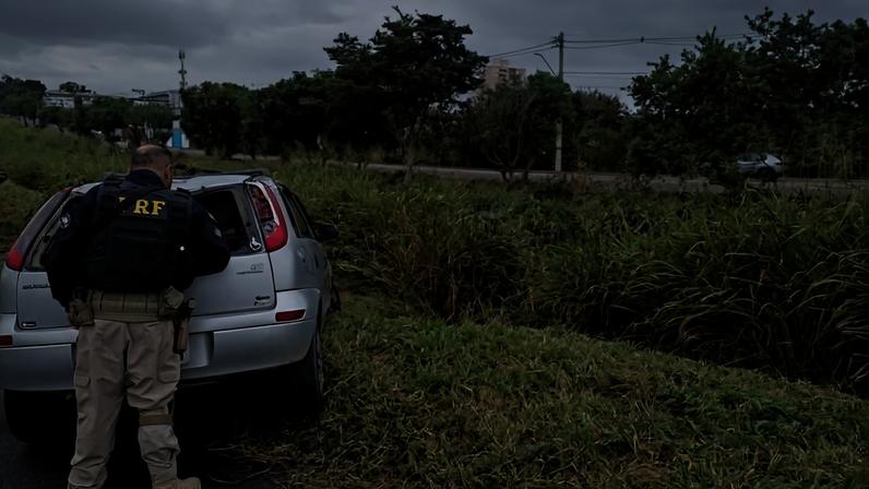 Policial rodoviário federal observa carro retirado de vala após pai ter supostamente capotado veículo com a filha dentro na rodovia Presidente Dutra, em São José dos Campos (SP)