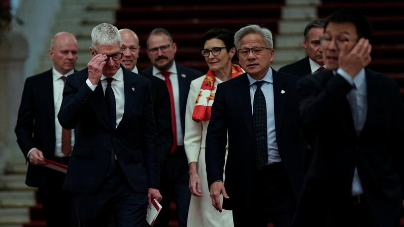 CEO da Apple, Tim Cook (à esq.), CEO da Nvidia, Jensen Huang (à dir.) e CEO do Citi, Jane Fraser (ao fundo), chegando para reunião com autoridade chinesa durante viagem de Trump à China