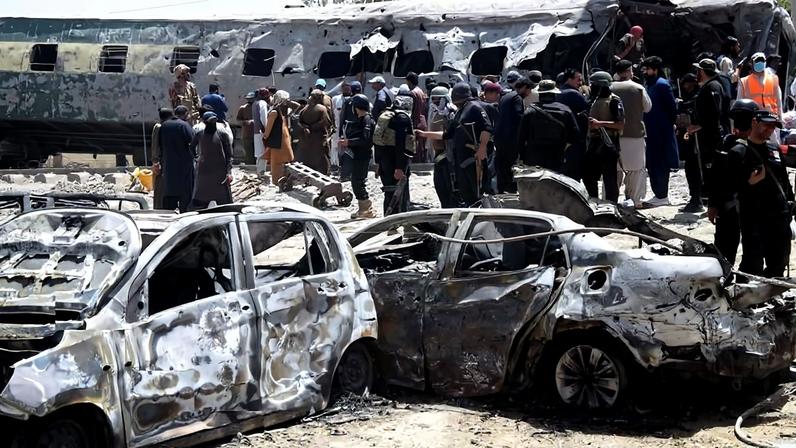Policiais e civis paquistaneses ao redor de veículos e do trem atingidos explosão provocada por ataque com bomba em Quetta, capital da província do Baluchistão, no Paquistão