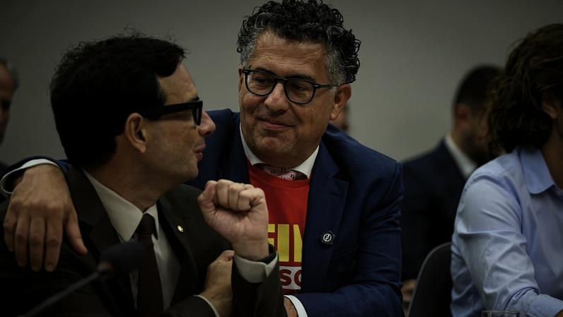 O deputado Alencar Santana (PT-SP), de camisa vermelha e blazer azul, preside a comissão especial que vota a PEC do fim da escala 6x1. Ao lado dele, o relator da matéria, deputado Leo Prates (Republicanos-BA).