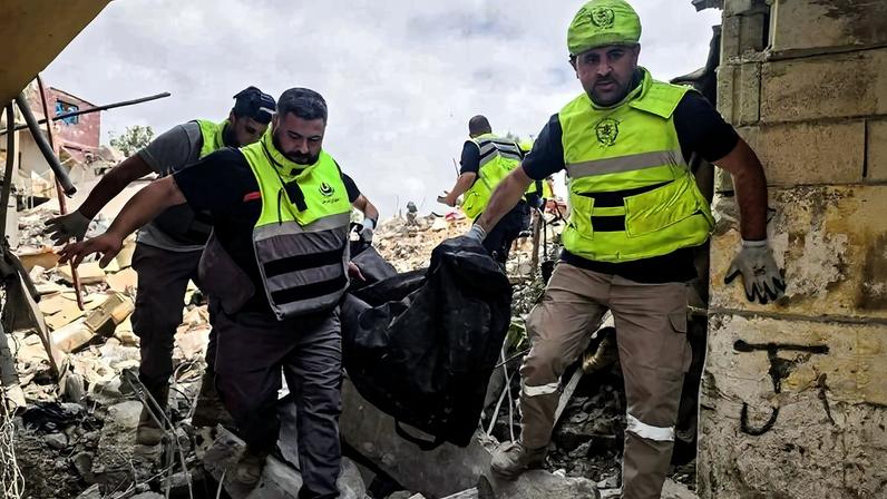 Socorristas removem corpo de destroços de edifício nos arredores de Tiro, na costa do sul do Líbano, após bombardeio de Israel