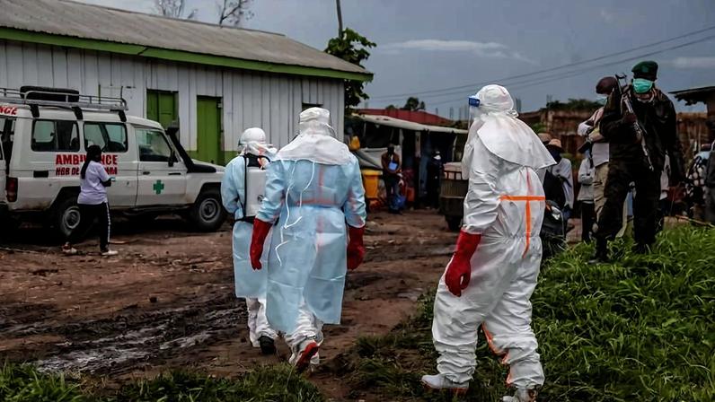 Equipe médica usando EPI (equipamento de proteção individual) caminha pelo hospital em Rwampara em 21 de maio de 2026