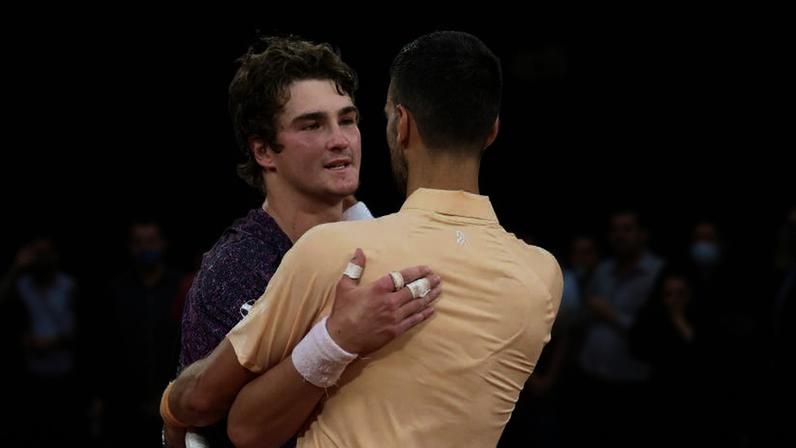 Djokovic (de costas) abraça João Fonseca após vitória do brasileiro em Roland Garros