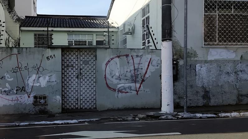 Muros de casa em avenida no centro de Manaus tem pichações em referência ao Comando Vermelho e letras do PCC apagadas com tinta branca