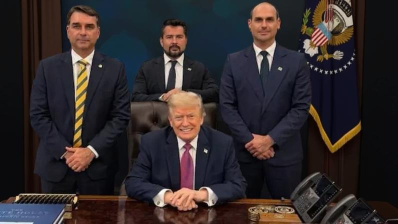 Em imagem publicada durante a viagem, Flávio Bolsonaro, Paulo Figueiredo e Eduardo Bolsonaro posam com Donald Trump