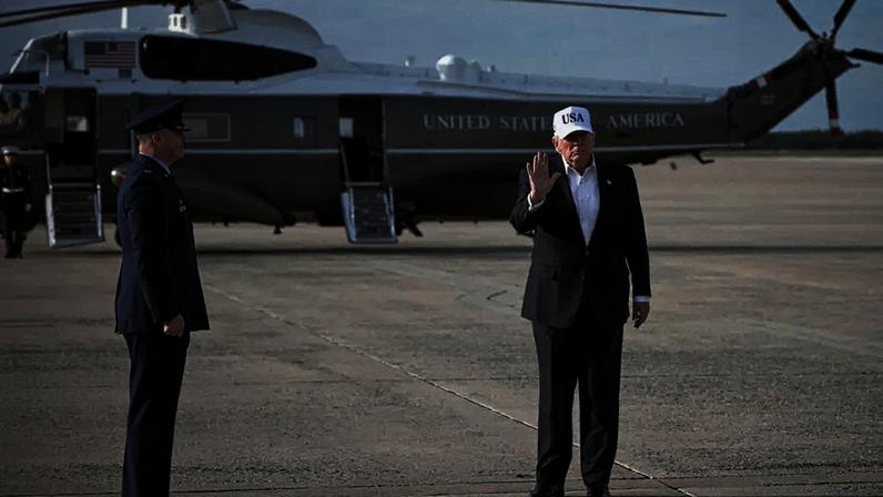 O presidente norte-americano Donald Trump cumprimenta a multidão após desembarcar do Air Force One em 15 de maio de 2026 na Base Aérea Conjunta Andrews, em Maryland.