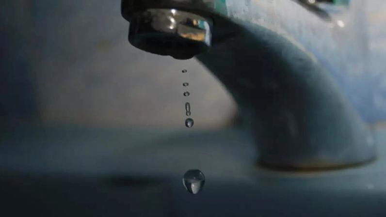 Close-up de uma gota de água caindo de uma torneira