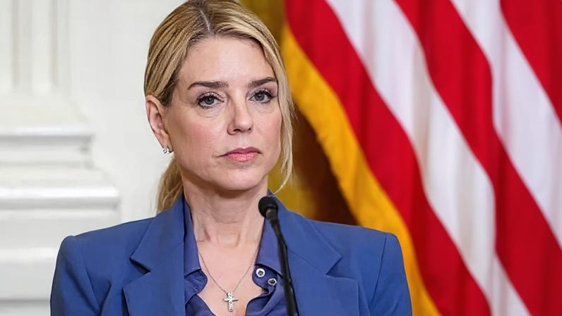 Bloomberg via Getty Images close-up of Pam Bondi, wearing blue suit, looking serious in front of a microphone